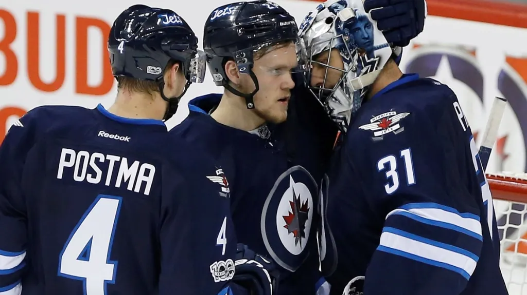Brankář Ondřej Pavelec se raduje z výhry se spoluhráči z Winnipegu