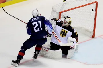 Dylan Larkin z USA překonává Mathiase Niederbergera z Německa