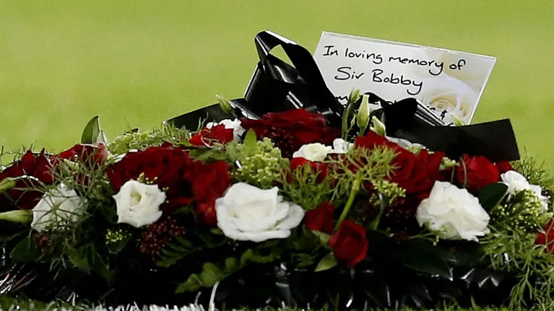 Smuteční věnec, který kapitán United Bruno Fernandes položil na hřiště po smrti legendy Sira Bobbyho Charltona