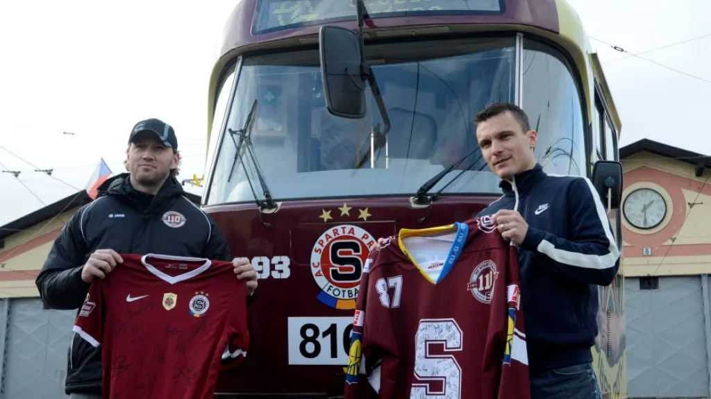 Petr Ton a David Lafata pózují s dresy před tramvají v klubových barvách Sparty