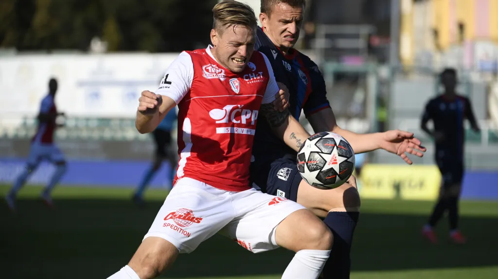 Tomáš Čelůstka z Pardubic si kryje míč před Janem Kopicem z Plzně