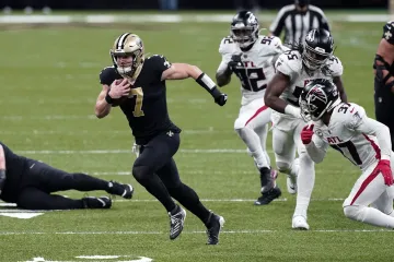 Quarterback New Orleans Taysom Hill uniká obraně Atlanty
