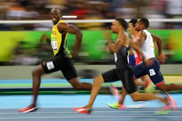 Usain Bolt stihl ve finiši i úsměv pro fotografa