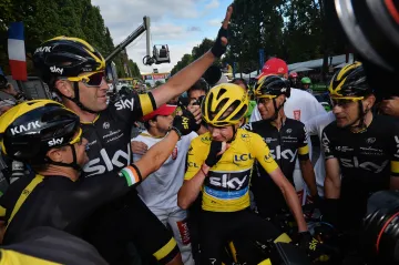 Chris Froome (urpostřed) slaví se svými týmovými kolegy vítězství na Tour de France