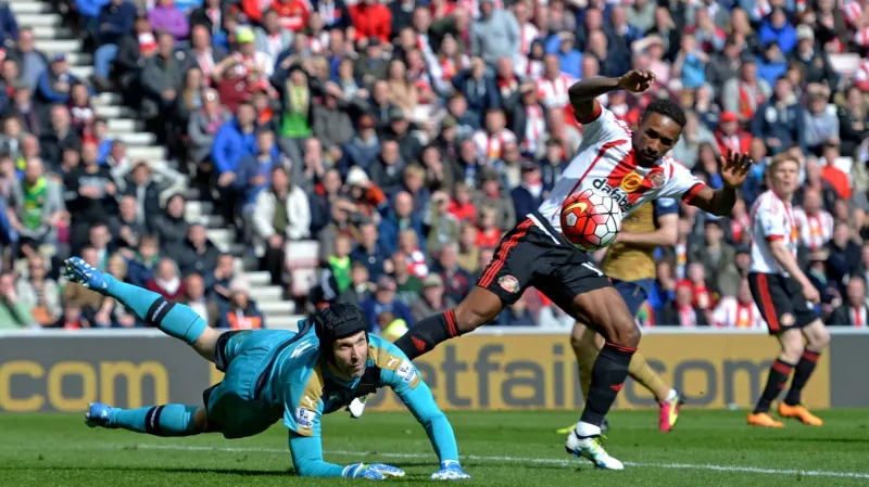 Petr Čech z Arsenalu chytá šanci Jermaina Defoea