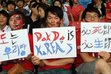 Korejští fanoušci vyjadřující podporu v teritoriálním sporu