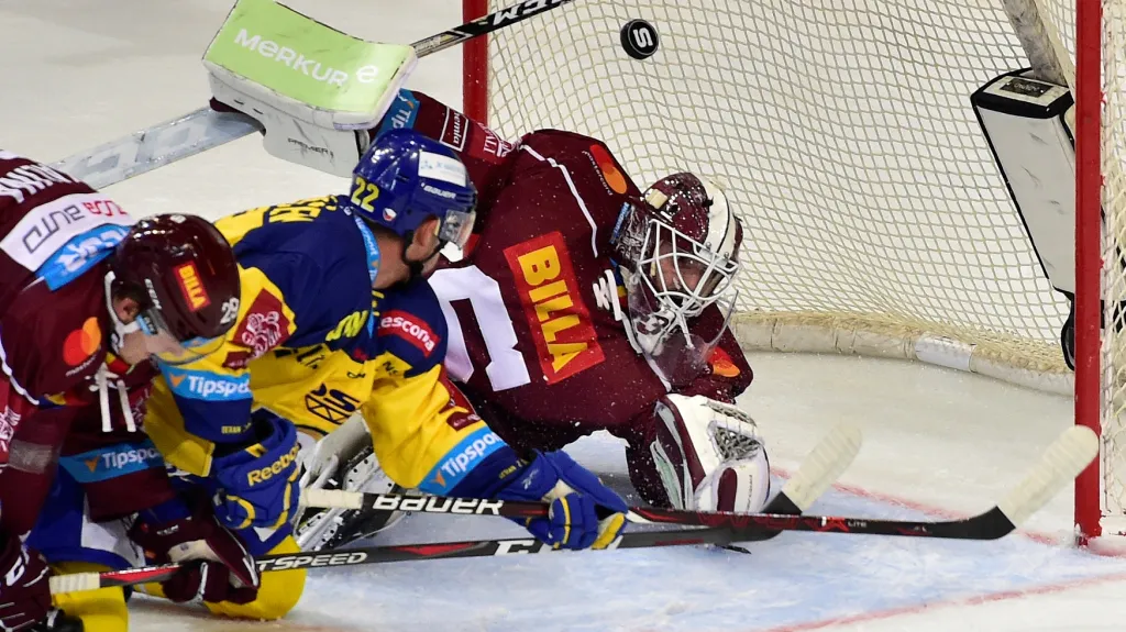 Brankář Sparty Machovský zasahuje proti střele Ondráčka ze Zlína