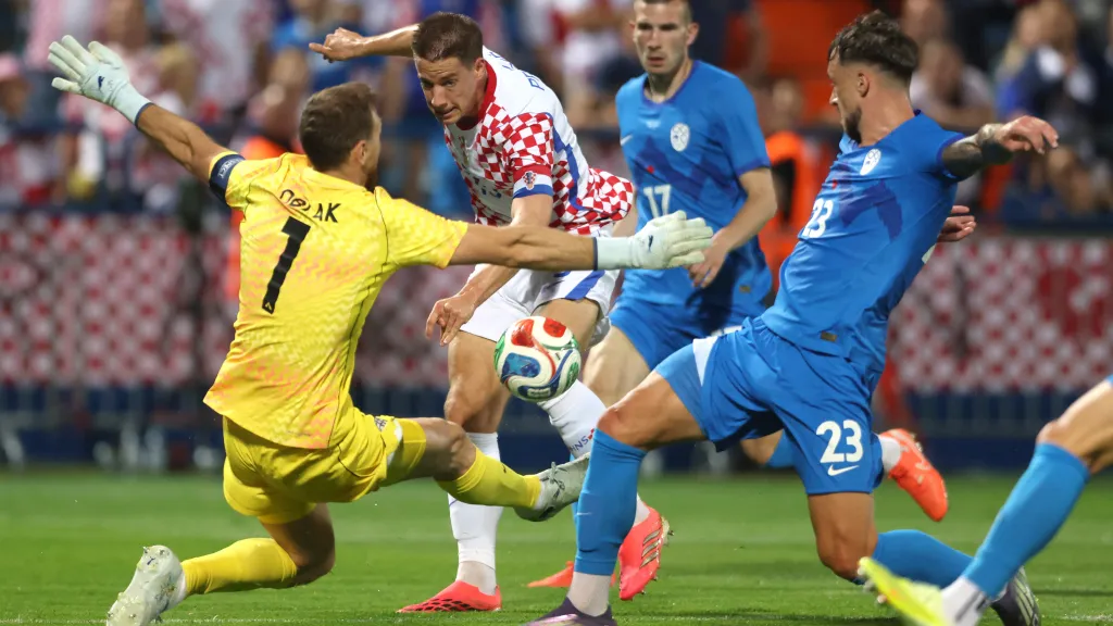 Chorvat Mario Pašalič před slovinským brankářem Janem Oblakem