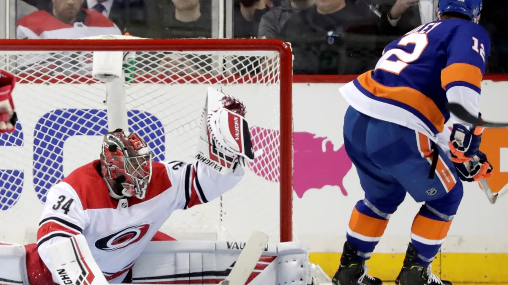 Český brankář Petr Mrázek zasahuje proti Andersi Leemu z Islanders