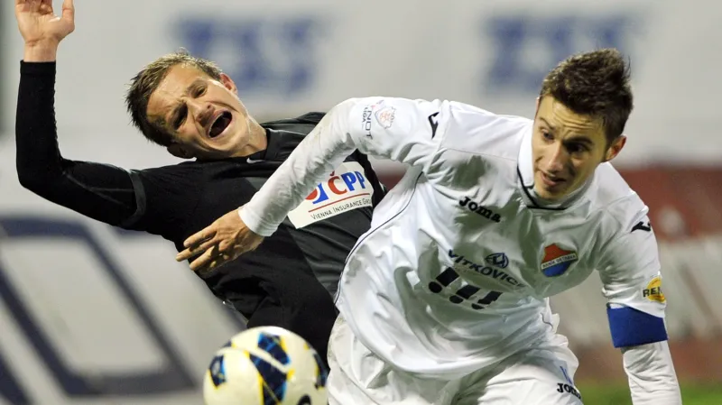 Ján Greguš z Baníku Ostrava (v bílém) bojuje o míč s jabloneckým Janem Kopicem