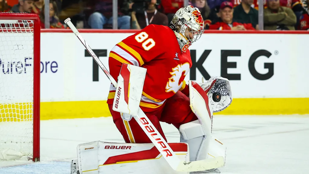 Brankář Daniel Vladař z Calgary chytá puk v utkání NHL