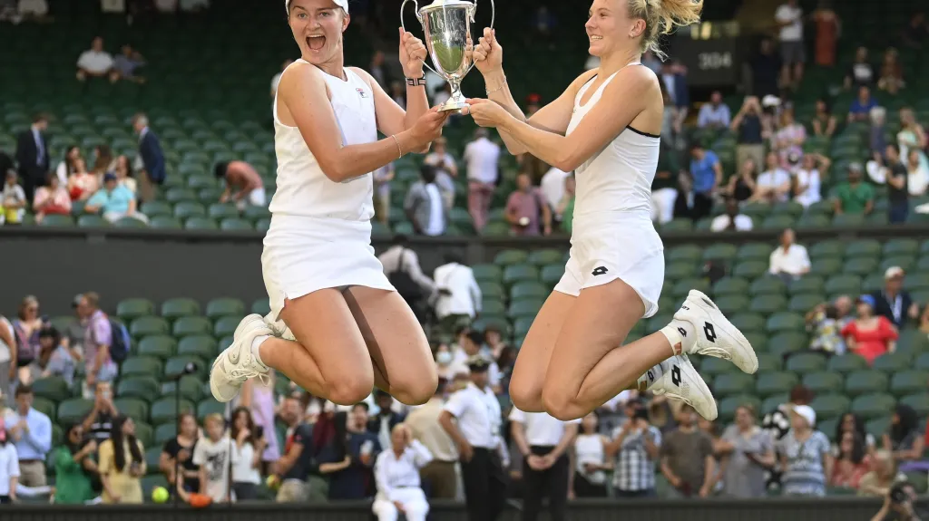 Barbora Krejčíková (vlevo) a Kateřina Siniaková s trofejí ve Wimbledonu