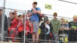 Fanoušci, smutně nahlížející přes plot do paddocku