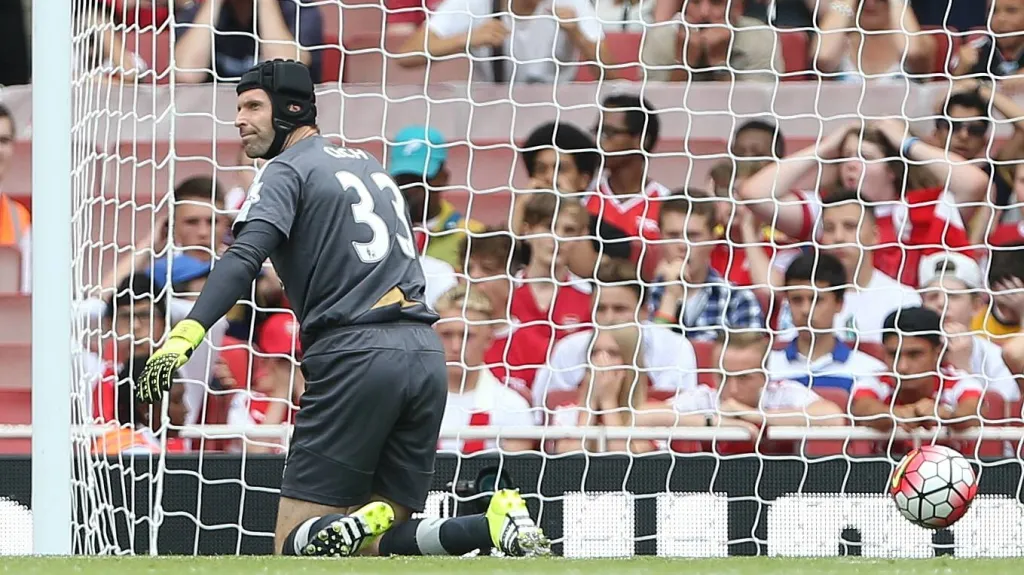 Brankář Arsenalu Petr Čech loví míč ze sítě