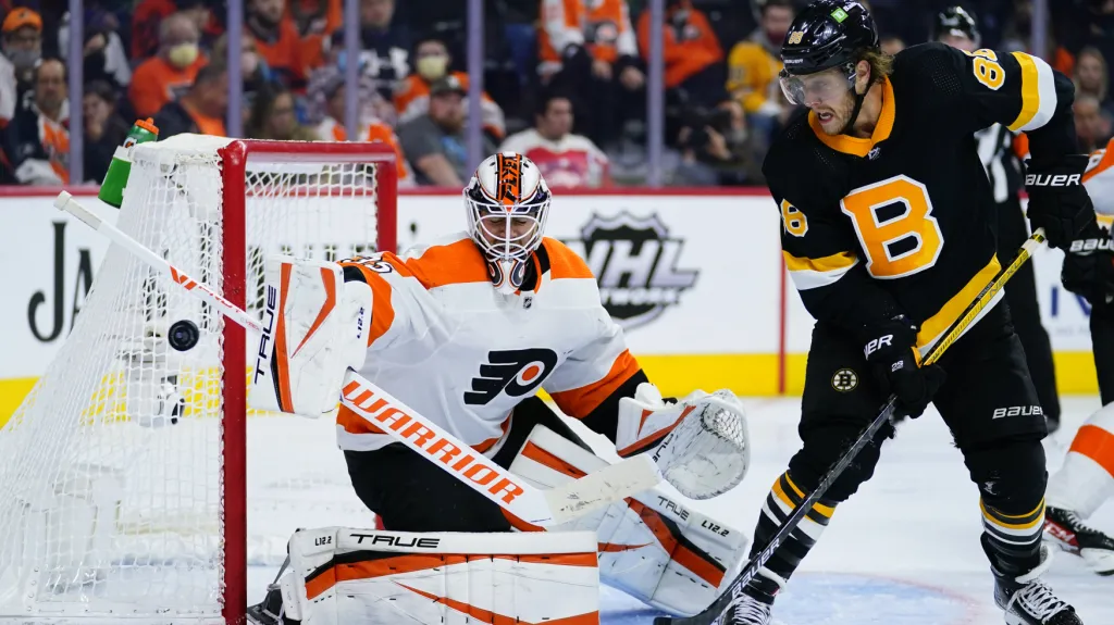 David Pastrňák tečuje před Martinem Jonesem