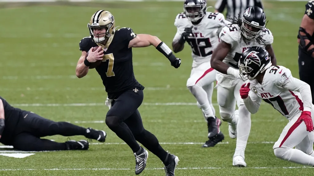 Quarterback New Orleans Taysom Hill uniká obraně Atlanty