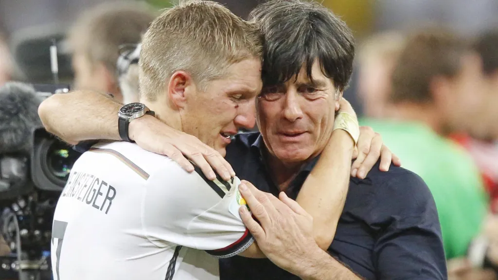 Dojatý trenér Německa Joachim Löw (vpravo) v objetí s Bastienem Schweinsteigerem