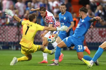 Chorvat Mario Pašalič před slovinským brankářem Janem Oblakem