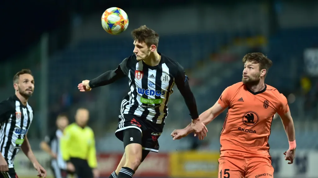 Budějovický stoper Havel odehrává míč před Wágnerem z Mladé Boleslavi