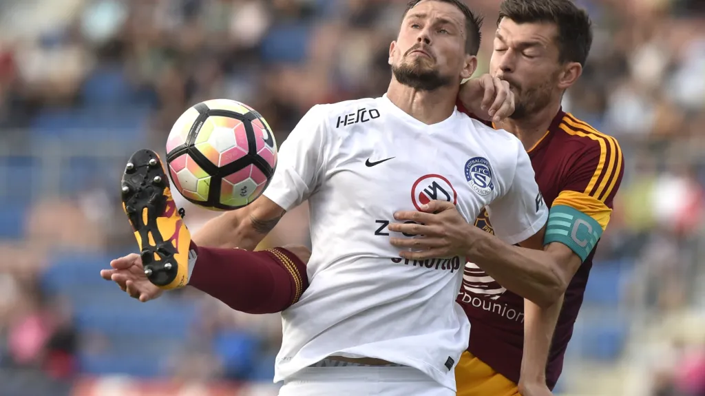 Jaroslav Diviš ze Slovácka (v bílém) se snaží pokrýt míč před Janem Šimůnkem z Dukly