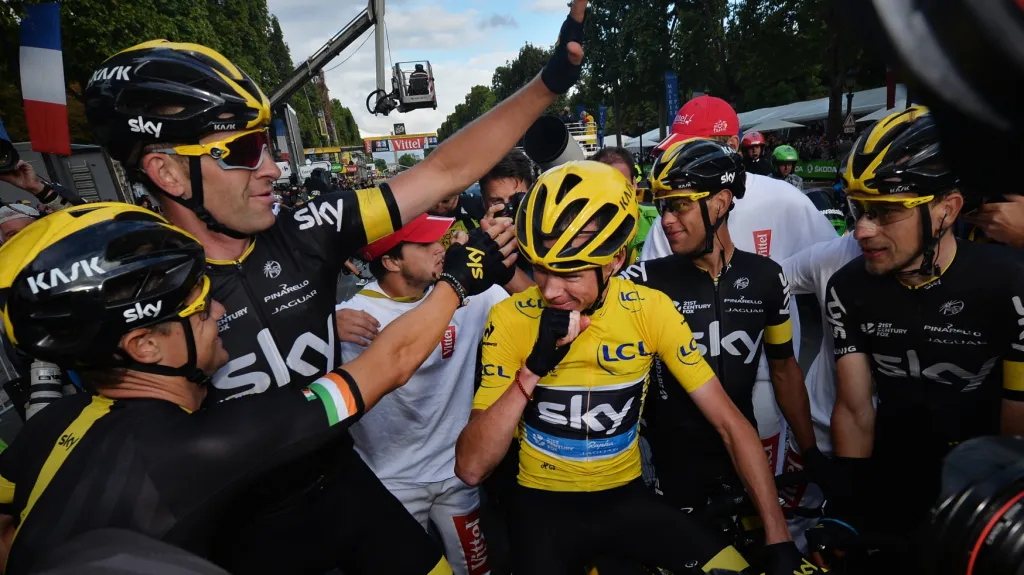 Chris Froome (urpostřed) slaví se svými týmovými kolegy vítězství na Tour de France