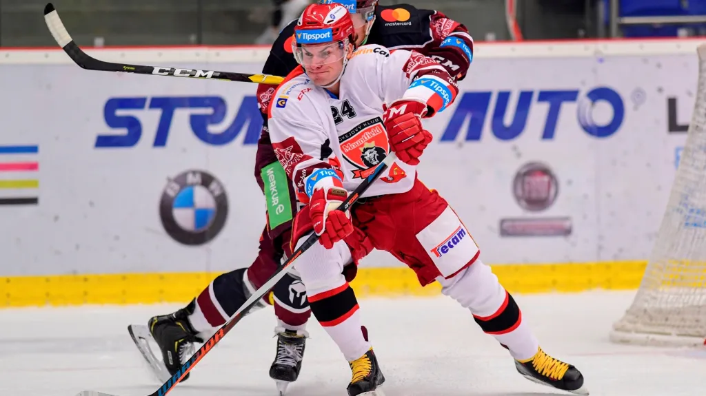 Obránce Hradce Králové Petr Zámorský odehrává puk před útočníkem Sparty