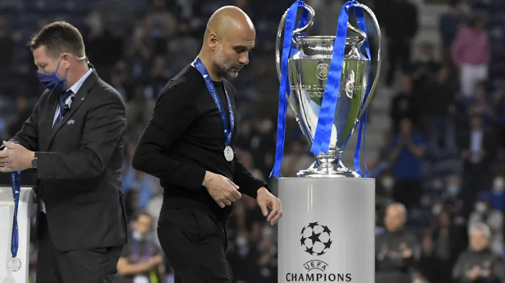 Kouč Manchesteru City Pep Guardiola zklamaně prochází kolem trofeje pro vítěze Ligy mistrů