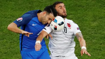 Francouz Adil Rami v hlavičkovém souboji s Armando Sadikem z Albánie