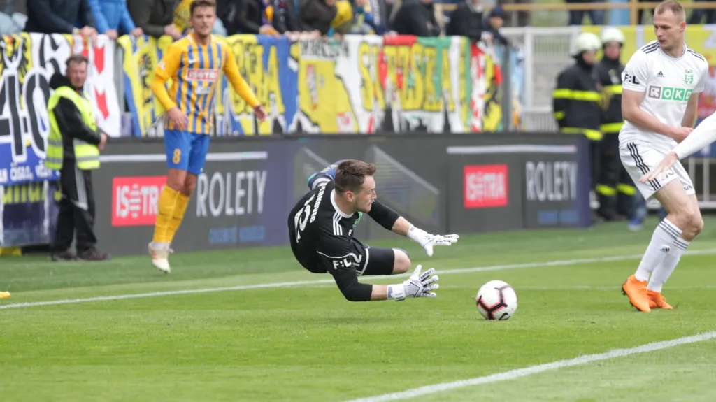 Brankář Karviné Martin Berkovec chytá míč v utkání v Opavě