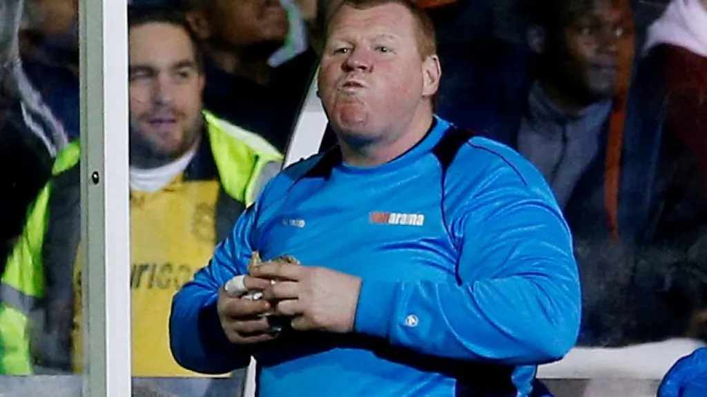 Brankář Wayne Shaw ze Suttonu jí během zápasu housku