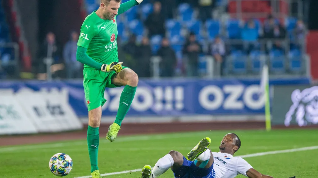 Brankář Slavie Ondřej Kolář v souboji s Damem Diopem z Baníku