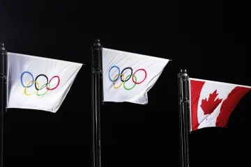 Dvě olympijské a jedna kanadská vlajka během ceremoniálu po skončení krasobruslařské soutěže