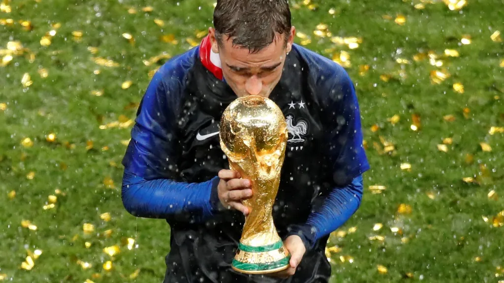 Francouz Antoine Griezmann líbá trofej pro mistry světa