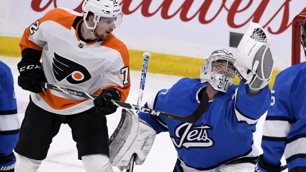 David Kaše v dresu Philadelphie cloní brankáři Winnipegu Connoru Hellebuyckovi