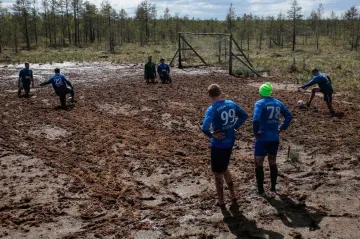 Fotbal na blátivém lesním hřišti u vesnice Pogi v leningradské oblasti v Rusku