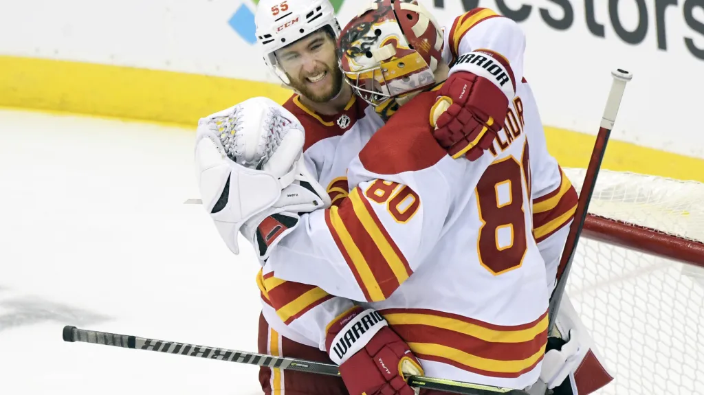 Brankář Daniel Vladař se raduje z výhry se spoluhráčem z Calgary s Noahem Hanifinem