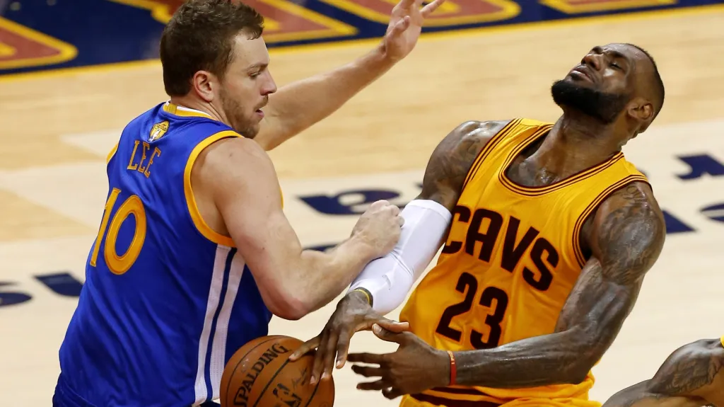 LeBron James z Clevelandu (vpravo) se snaží prosadit přes Davida Leeho z Golden State