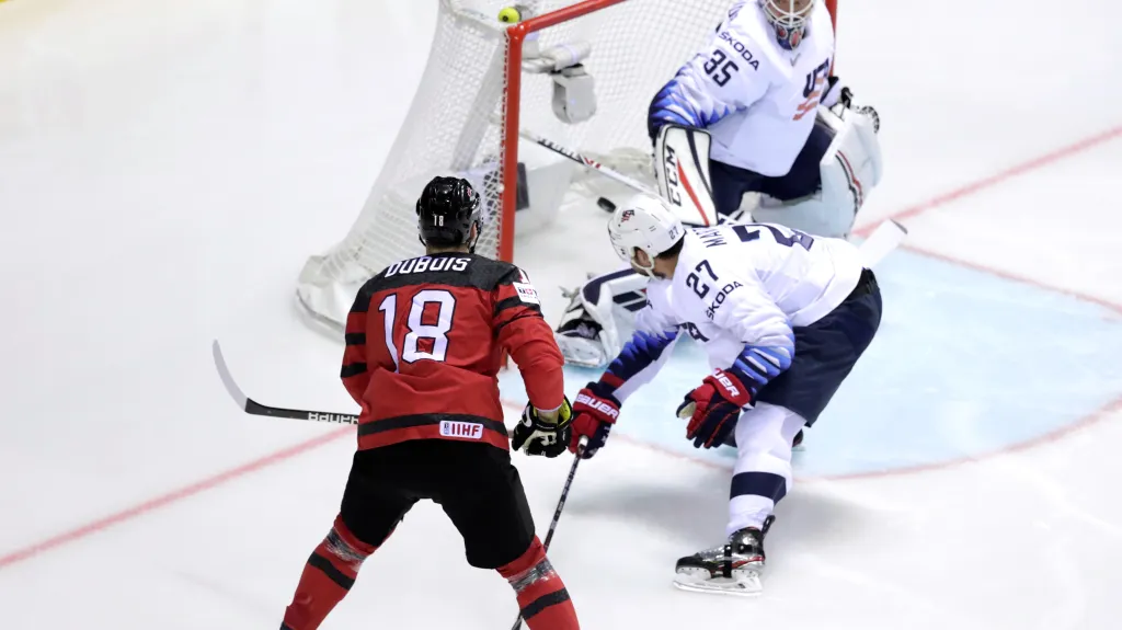 Kanaďan Pierre-Luc Dubois překonává amerického brankáře Coryho Schneidera