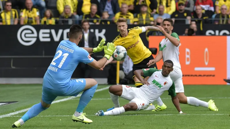 Tomáš Koubek z Augsburgu zasahuje v utkání s Dortmundem