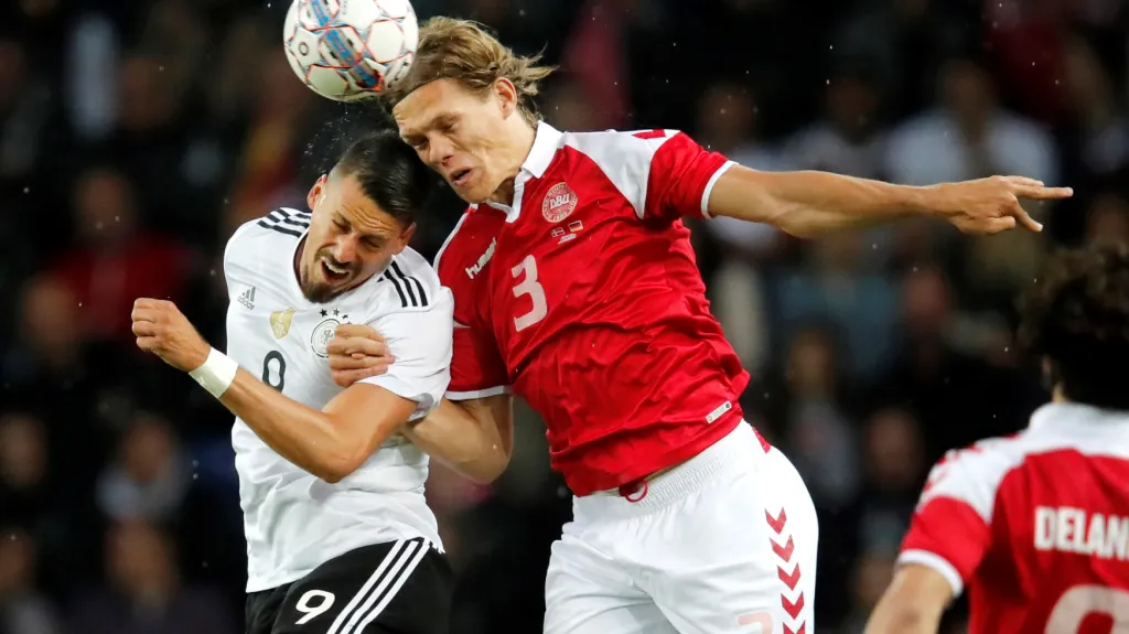 Jannik Vestergaard z Dánska (vpravo) v hlavičkovém souboji se Sandrem Wagnerem z Německa