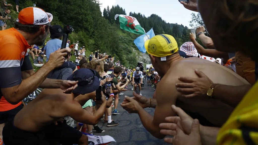 Tadej Pogačar v úzké uličce mezi fanoušky