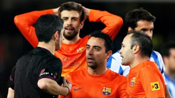 Pique, Hernandez a Iniesta z Barcelony diskutují s rozhodčím