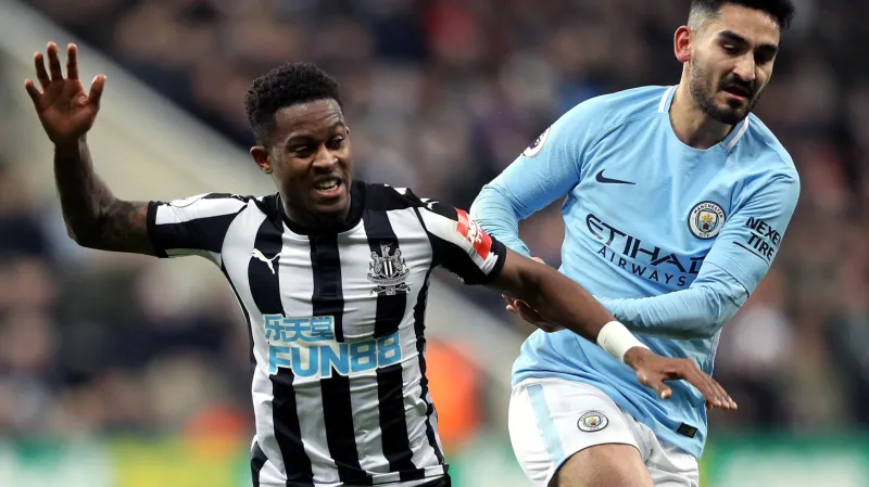 Rolando Aarons z Newcastlu (vlevo) padá po souboji s Ilkayem Gündoganem z Manchesteru City
