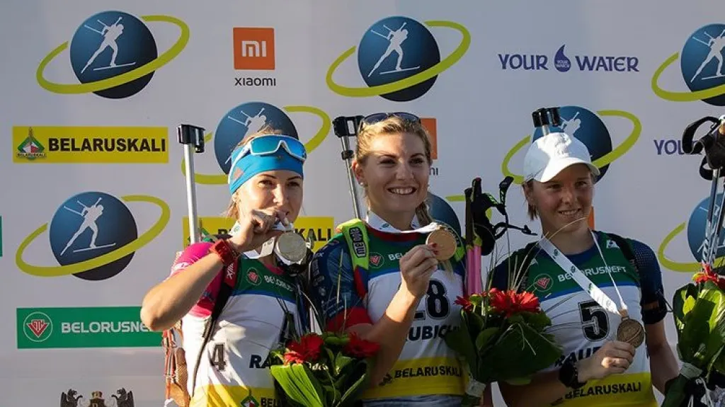 Lucie Charvátová (uprostřed) se zlatou medailí na MS v letním biatlonu
