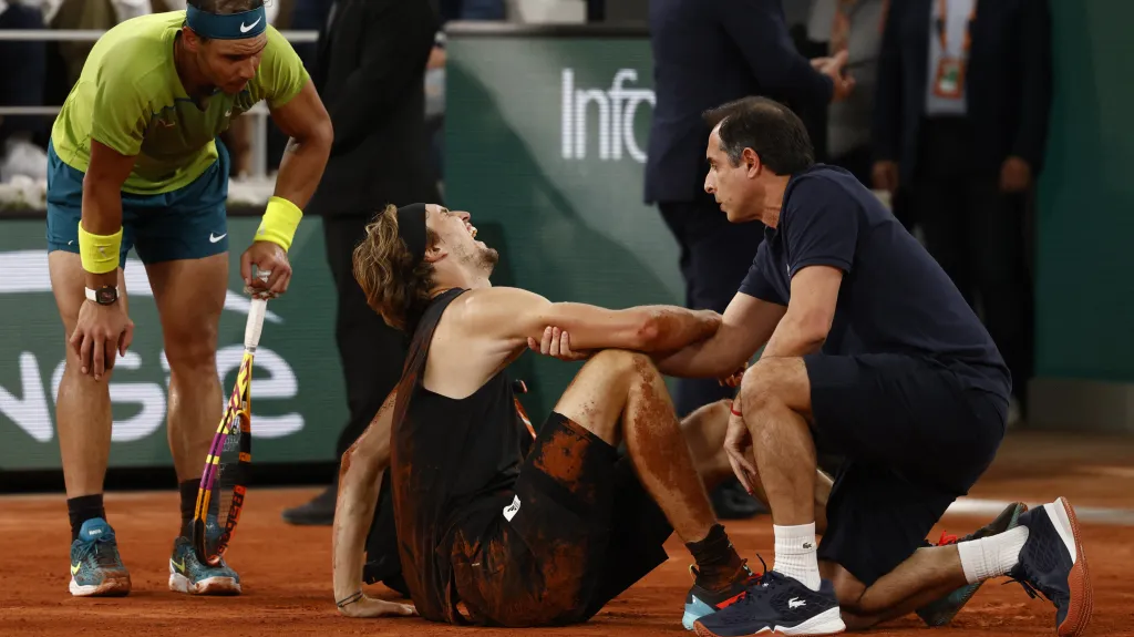 Rafael Nadal se sklání nad zraněným Alexandrem Zverevem
