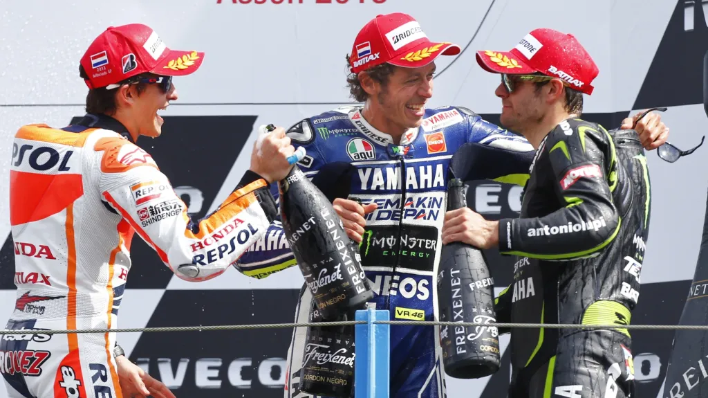 Ital Valentino Rossi (uprostřed) slaví vítězství ve VC Nizozemska s Markem Márguezem ze Španělska (vlevo) a Britem Calem Crutchlowem