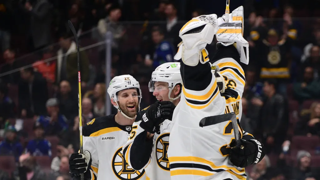 Brankář Linus Ullmark oslavuje se spoluhráči z Bostonu vstřelený gól