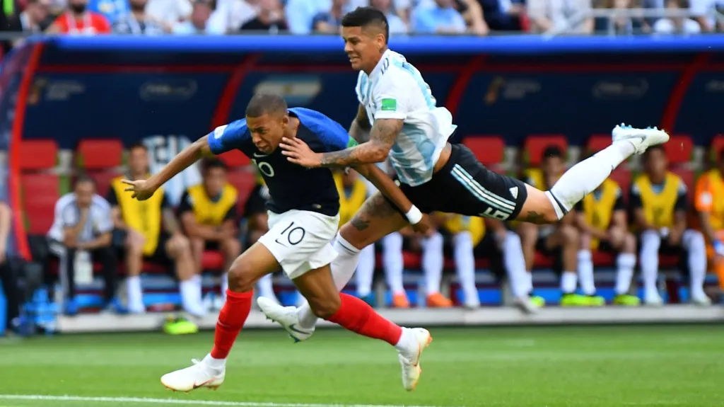 Francouz Kylian Mbappé utíká Marcosovi Rojovi z Argentiny