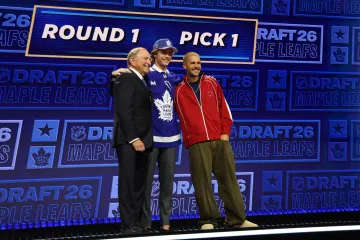 Jednička draftu NHL Gavin McKenna v dresu Toronta pózuje fotografům s komisionářem NHL Garym Bettmanem a zpěvákem Justinem Bieberem