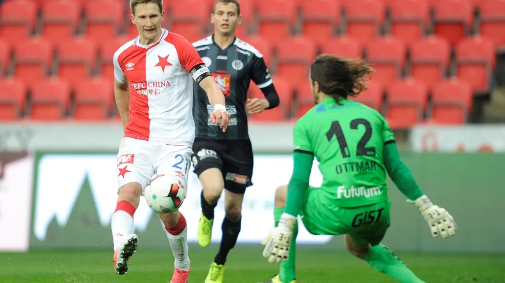Útočník Slavie Milan Škoda přehazuje brankáře Hradce Králové Radima Ottmara